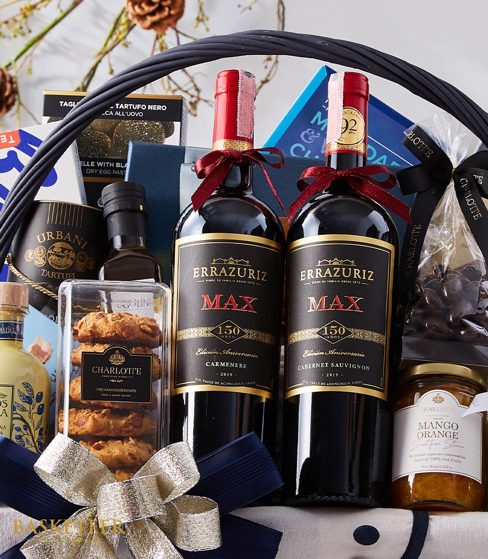 Luxury red wine gift basket with Errazuriz bottles, gourmet chocolates, truffles, and preserves in dark woven basket