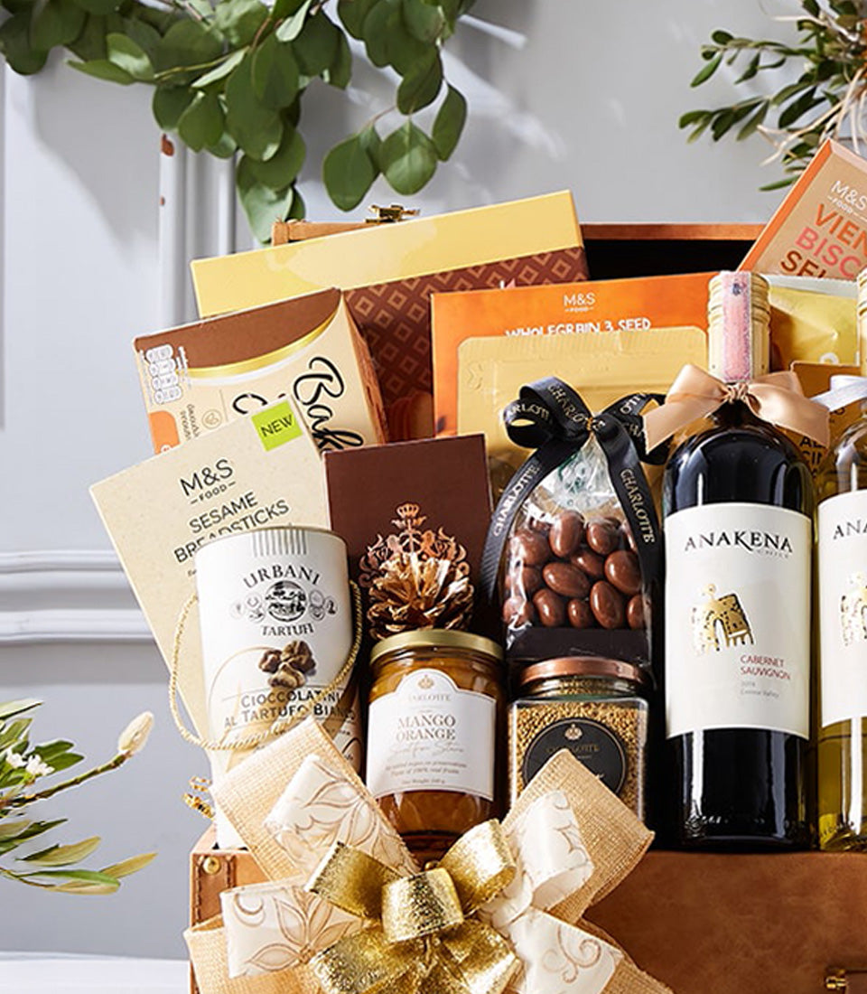 Luxury wine gift hamper with red and white wine, gourmet chocolates, preserves, crackers, and artisan treats in wooden chest