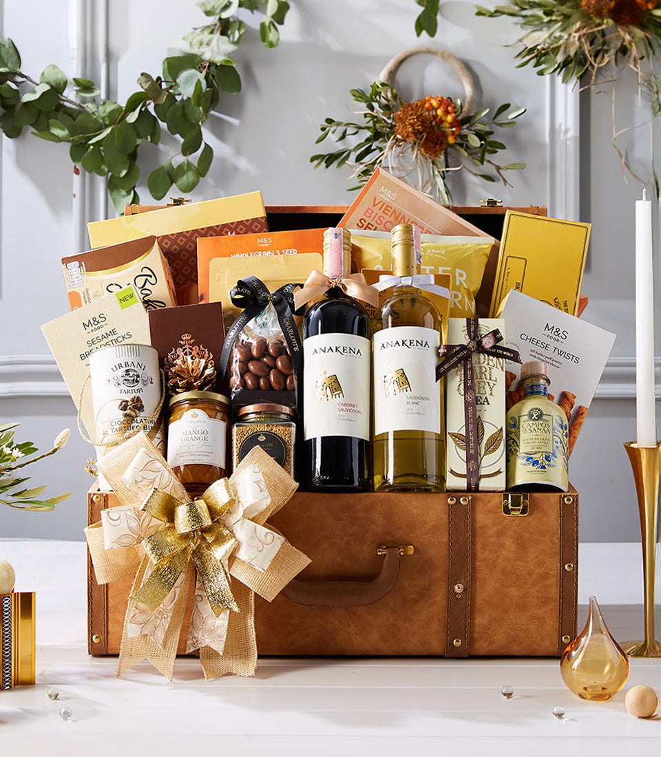 Luxury brown leather suitcase gift hamper with red and white wine, gourmet crackers, cheese, and chocolate truffles with