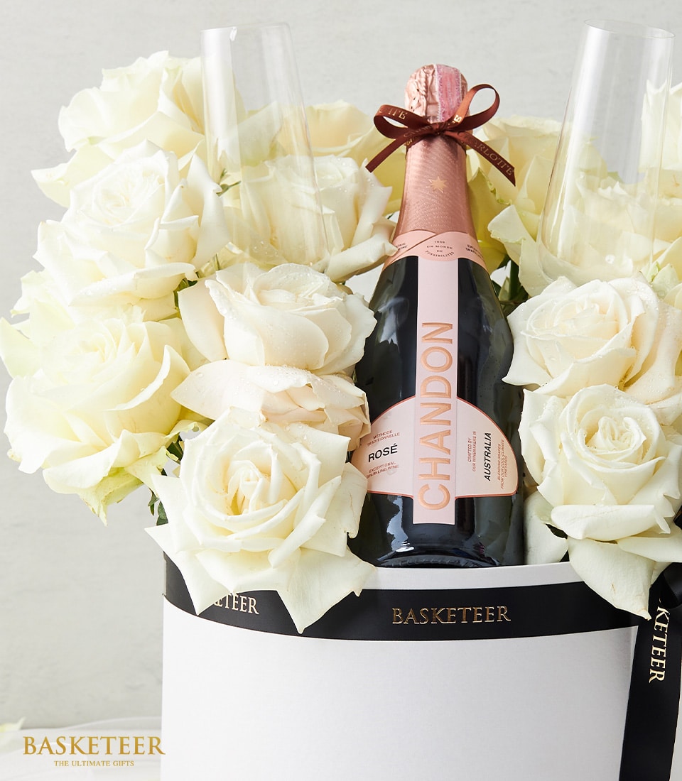 White rose bouquet with Chandon rosé sparkling wine and champagne flutes in luxury gift box