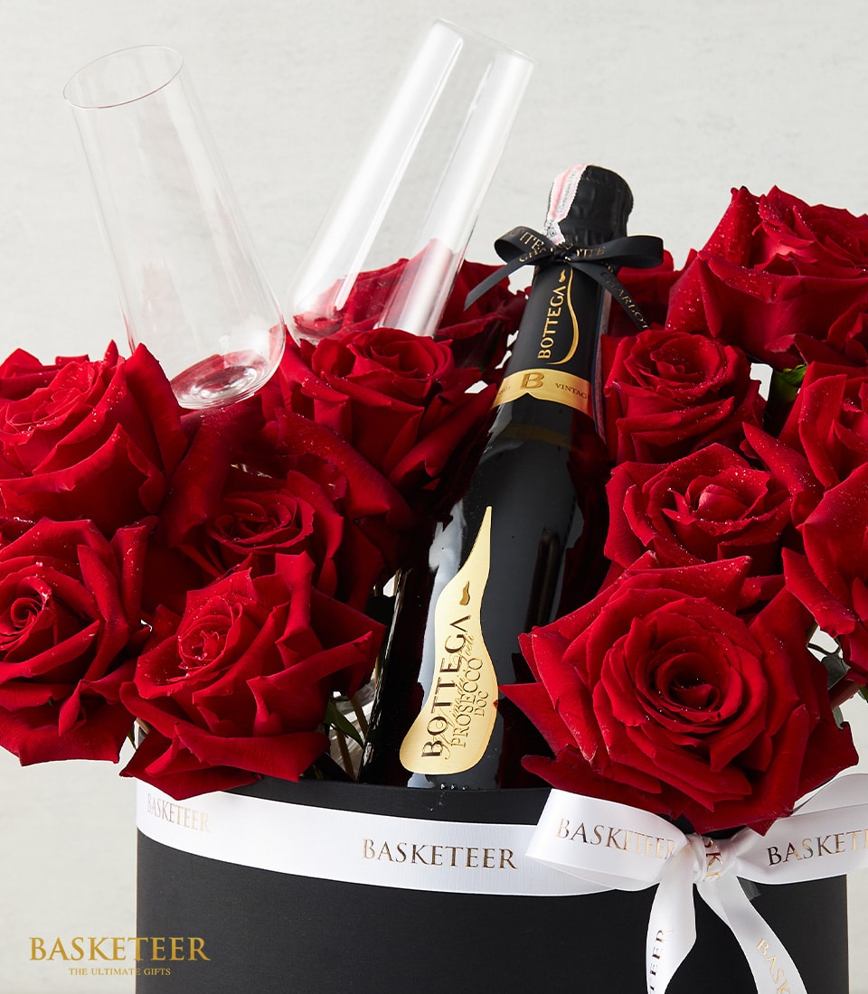 Luxury Valentine's gift box with red roses, champagne flutes, and sparkling wine with gold label