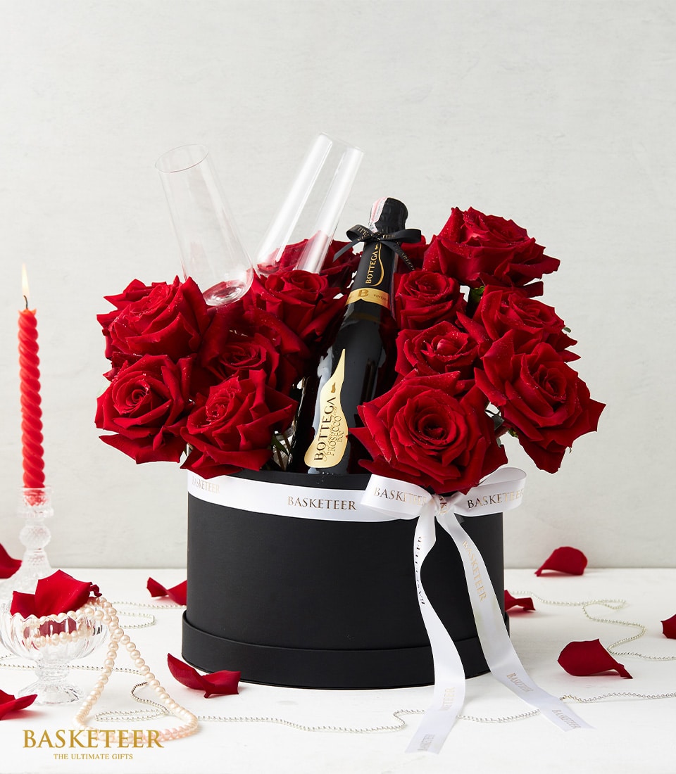 Luxury Valentine's gift set with red roses, champagne bottle, and stemless flutes in black box