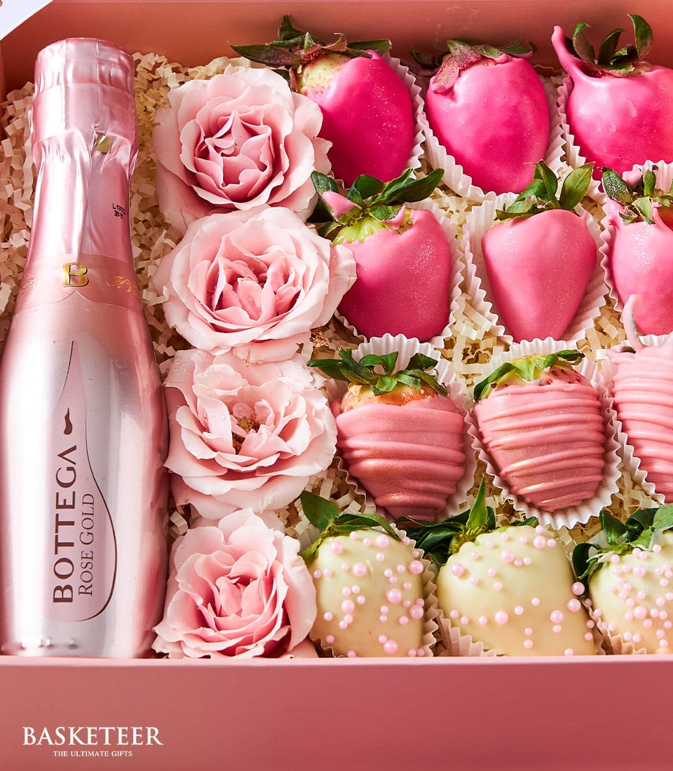Rosé sparkling wine with fresh roses and chocolate-covered strawberries in pink Valentine gift box