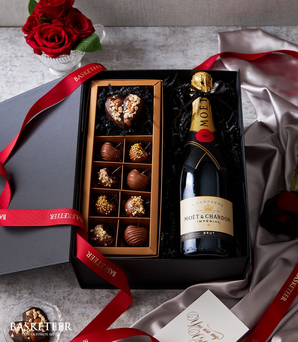 Luxury champagne and chocolate gift box with Moët & Chandon, heart-shaped truffles, and red ribbon for Valentine's Day