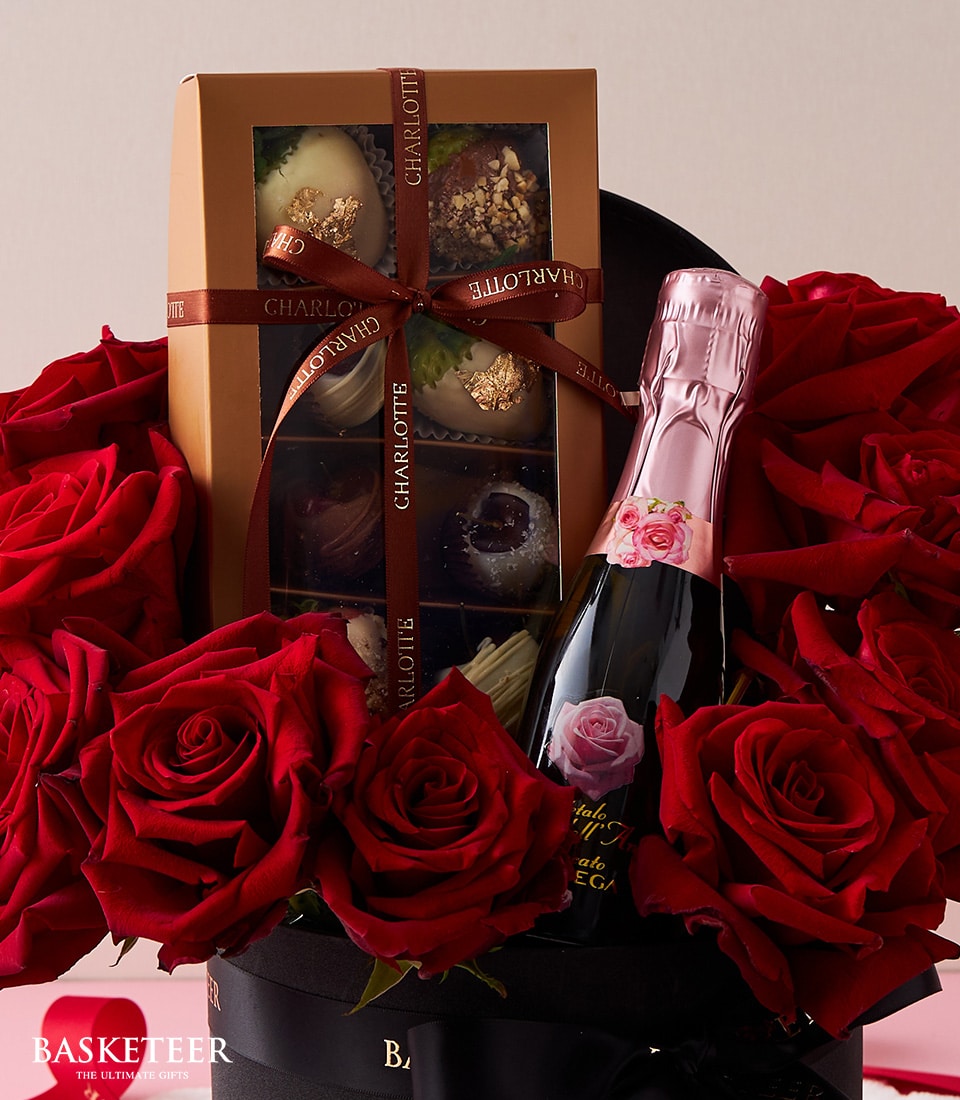 Luxury Valentine's gift set with red roses, sparkling wine, and Charlotte Bakery chocolate strawberries in black hatbox