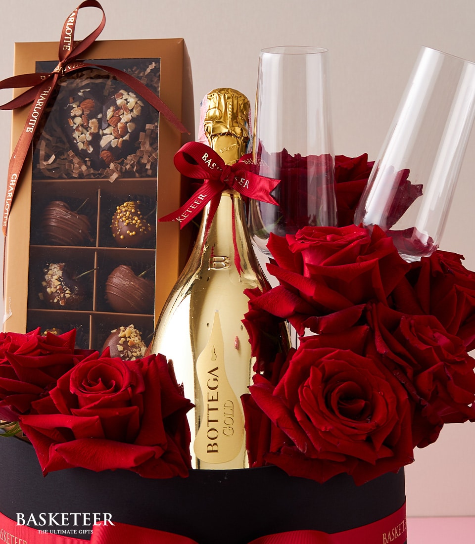 Sparkling wine, red roses, and chocolates luxury gift set in black presentation box for anniversaries