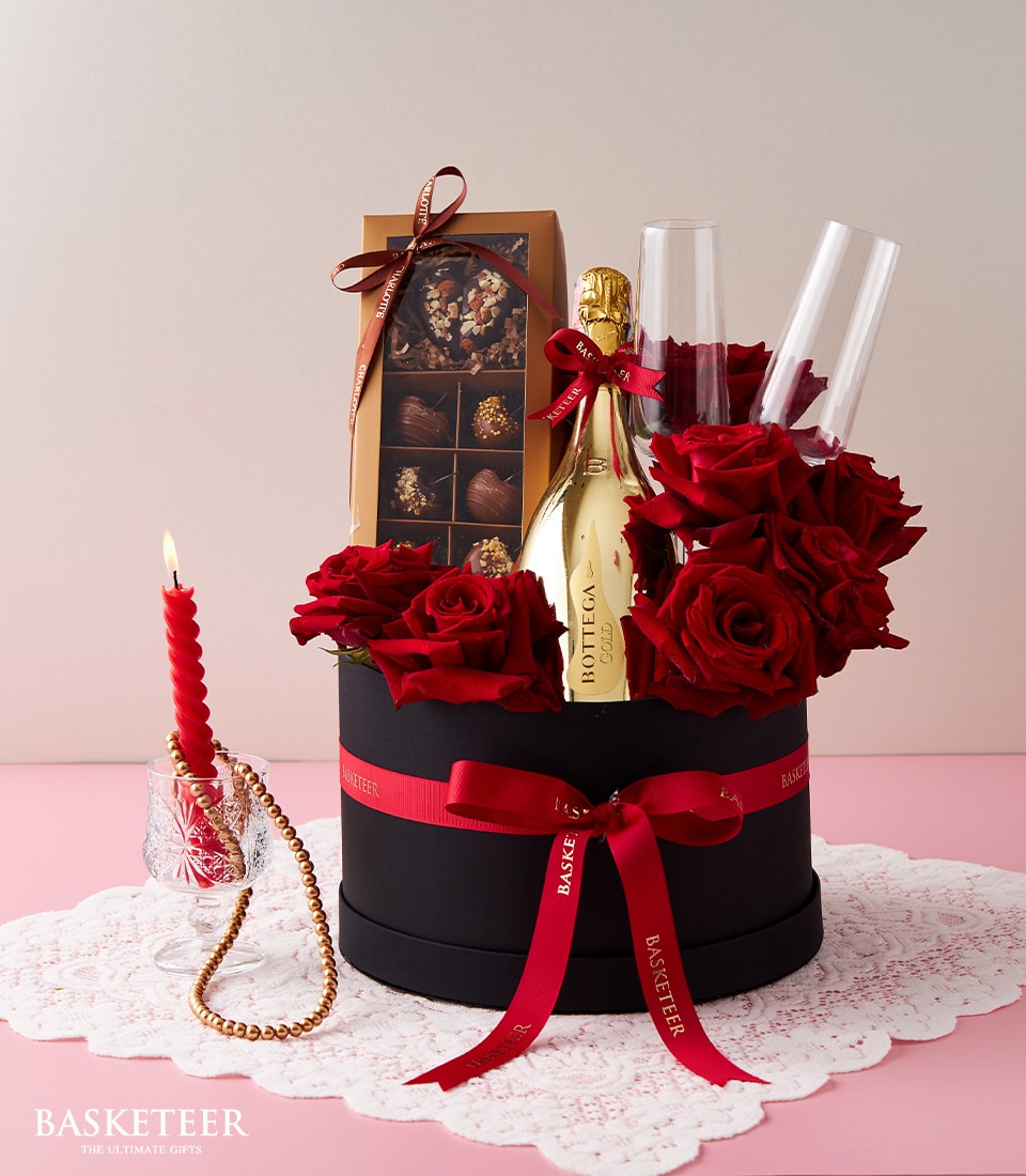 Luxury sparkling wine gift set with red roses, Bottega Gold champagne, chocolate truffles, and champagne flutes in black