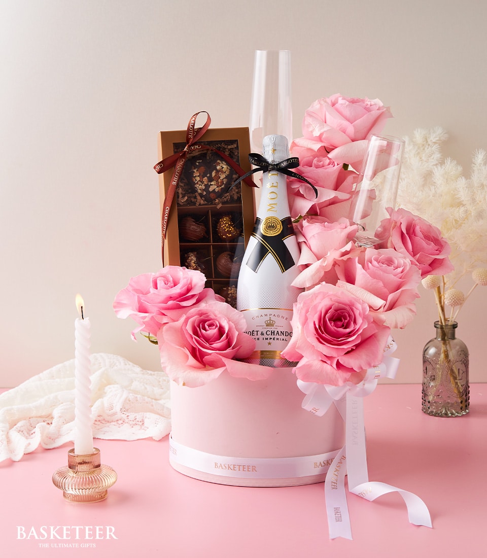 Moët Champagne bottle with pink roses, luxury chocolates, and champagne flutes in elegant pink gift box for anniversaries