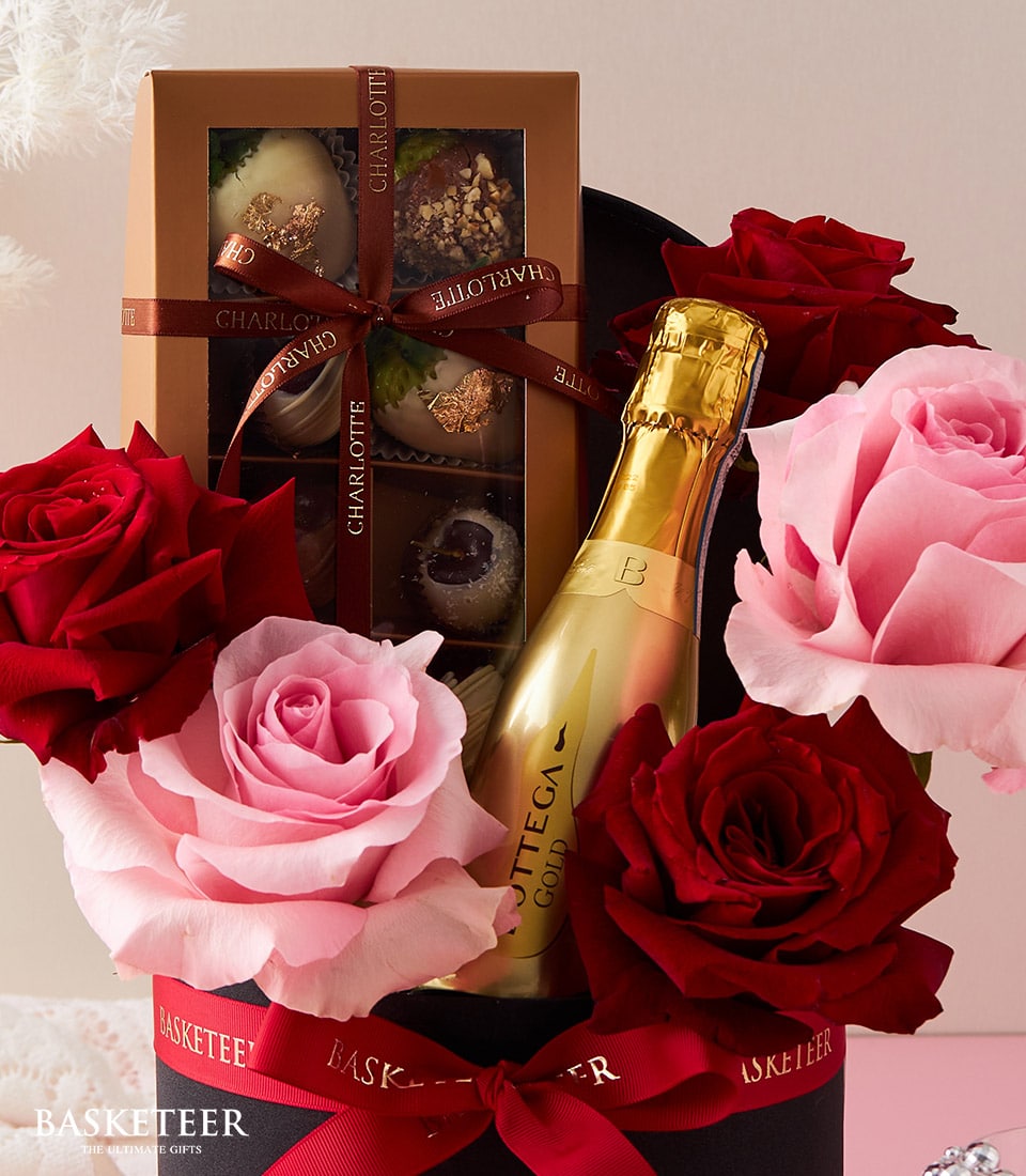 Champagne and chocolate anniversary gift with red and pink roses in black luxury box