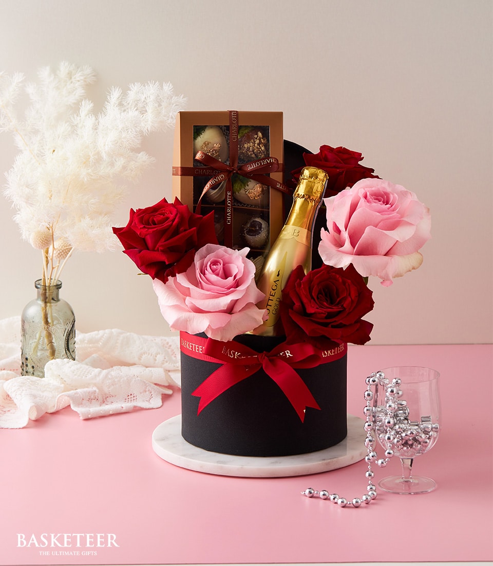 Luxury champagne gift box with red and pink roses, Bottega Gold sparkling wine, and chocolate-covered strawberries for