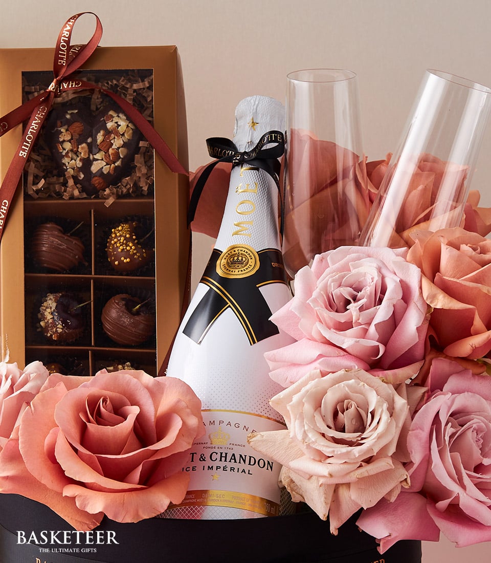 Luxury Moët champagne gift set with fresh roses, artisan chocolates, and champagne flutes for anniversary celebrations