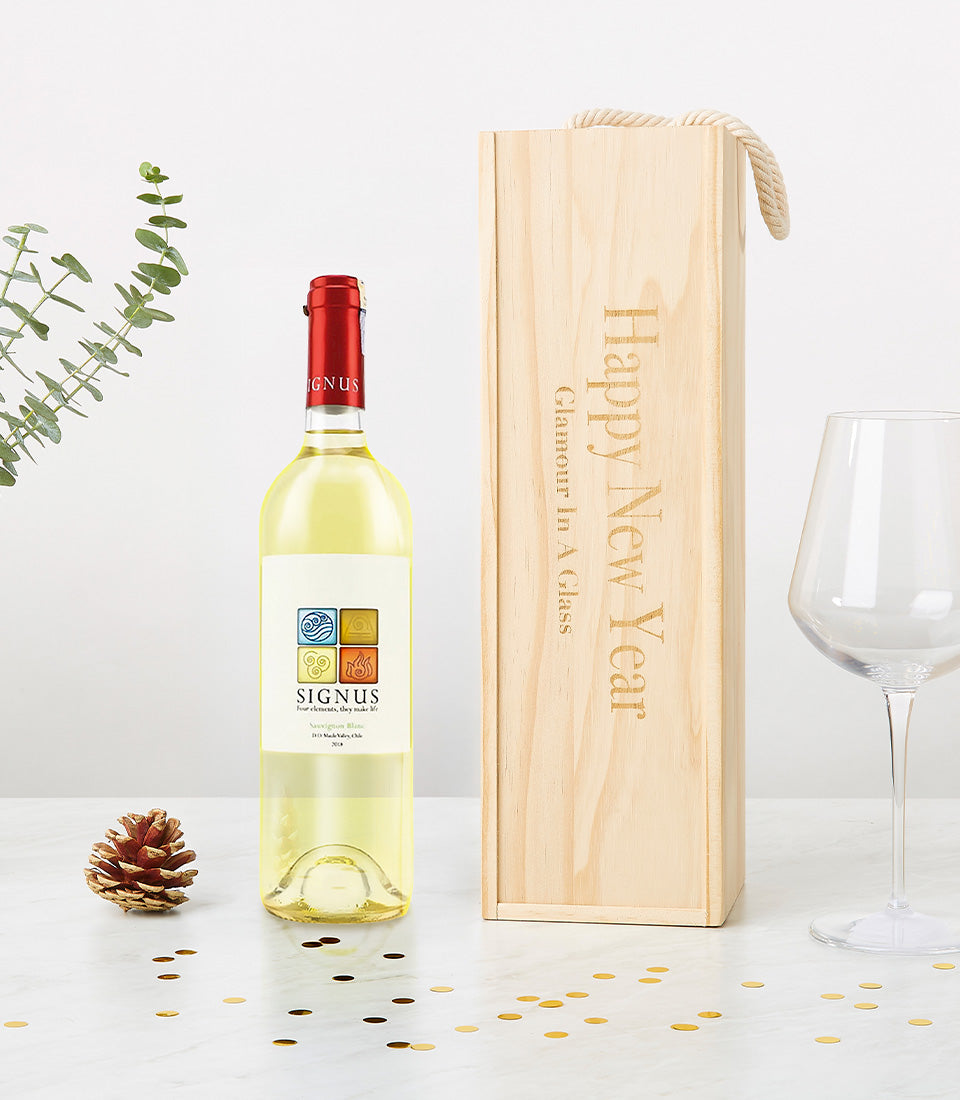 Signus white wine with personalized wooden gift box, gold confetti, and eucalyptus on marble