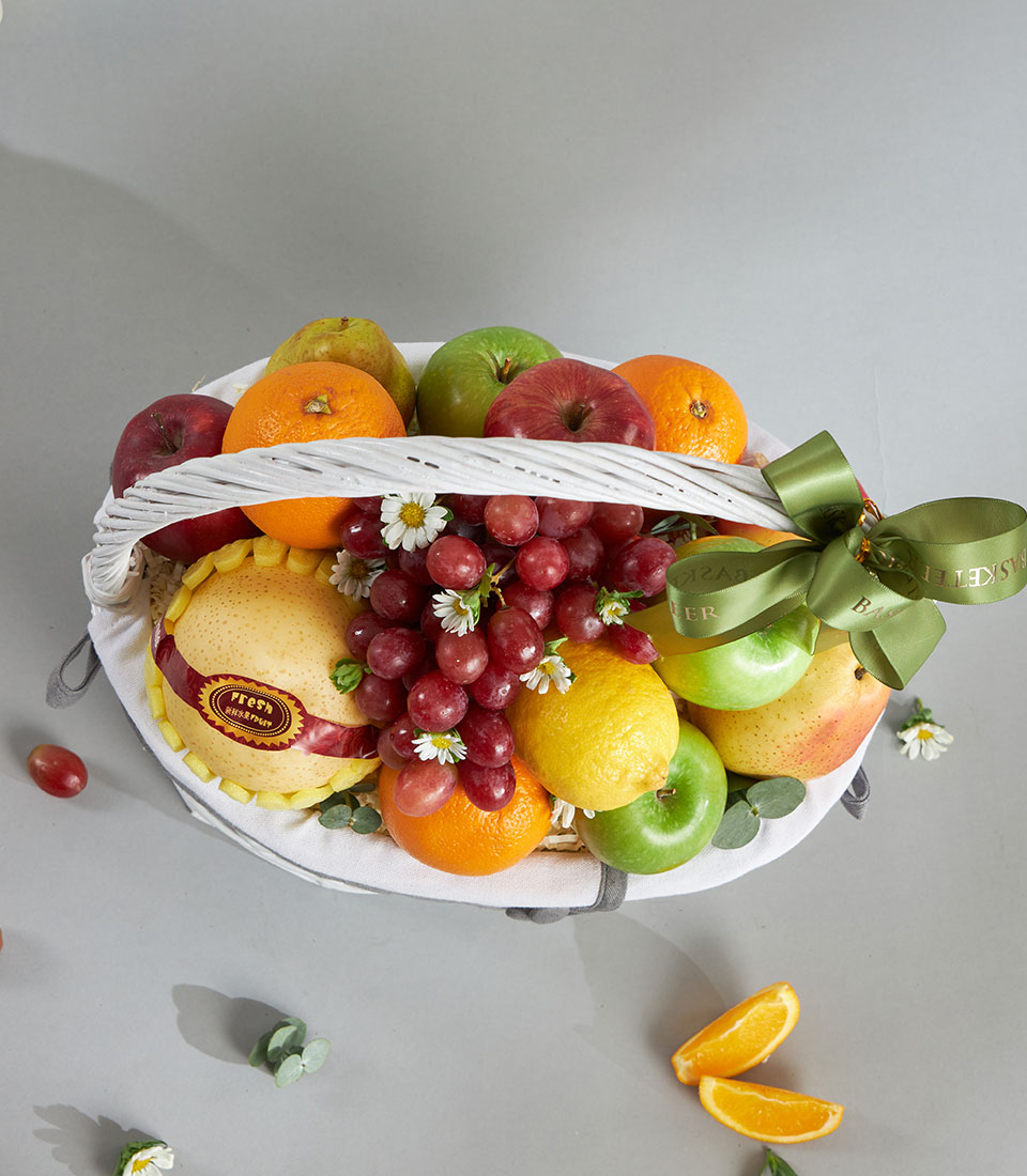 Premium fresh fruit basket with Granny Smith apples, red grapes, and citrus in white woven basket