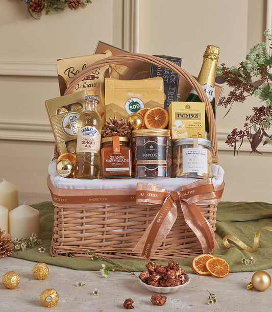 Golden gourmet gift basket with champagne, tea, marmalade, and chocolate treats for New Year celebrations