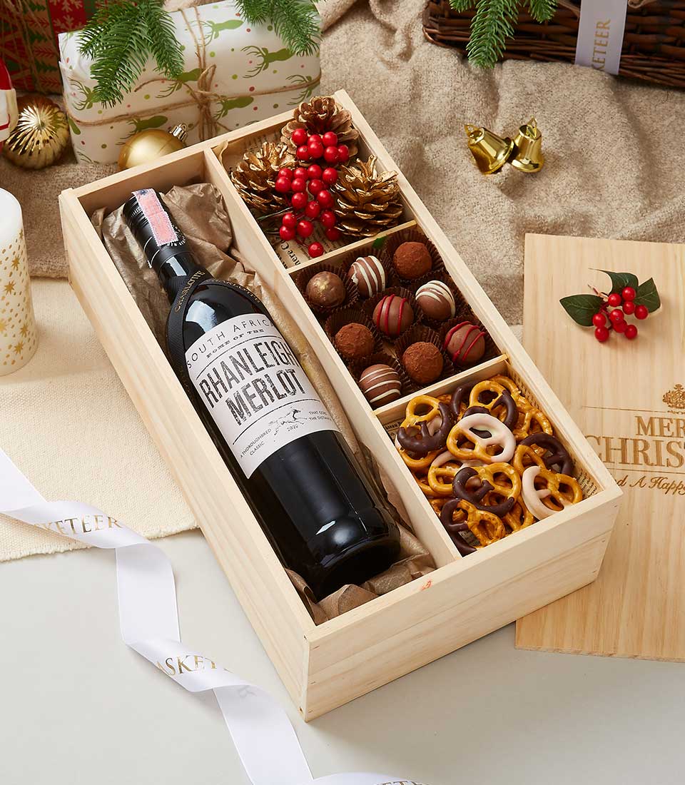 Premium red wine, chocolate truffles, and pretzels in natural wooden gift crate with festive holiday presentation