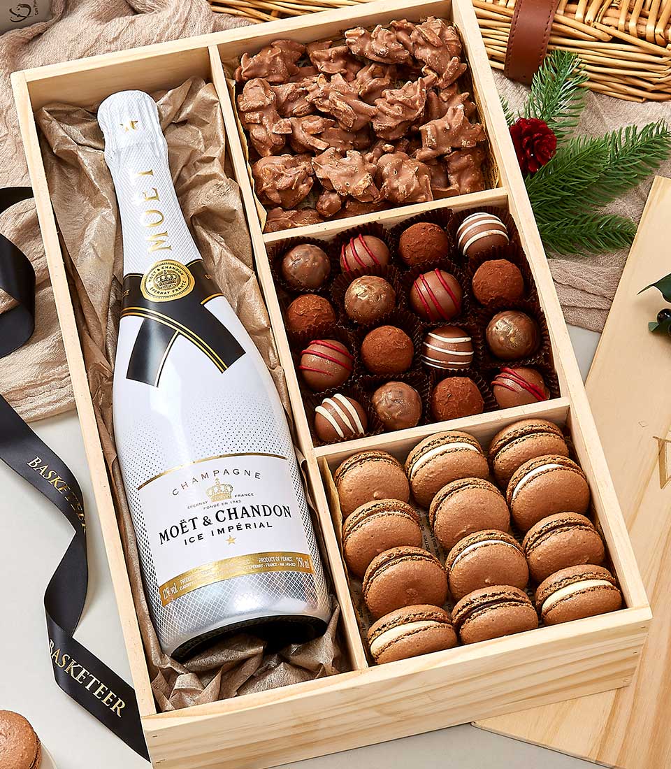 Luxury wooden gift box with Moët & Chandon champagne, chocolate clusters, truffles, and macarons