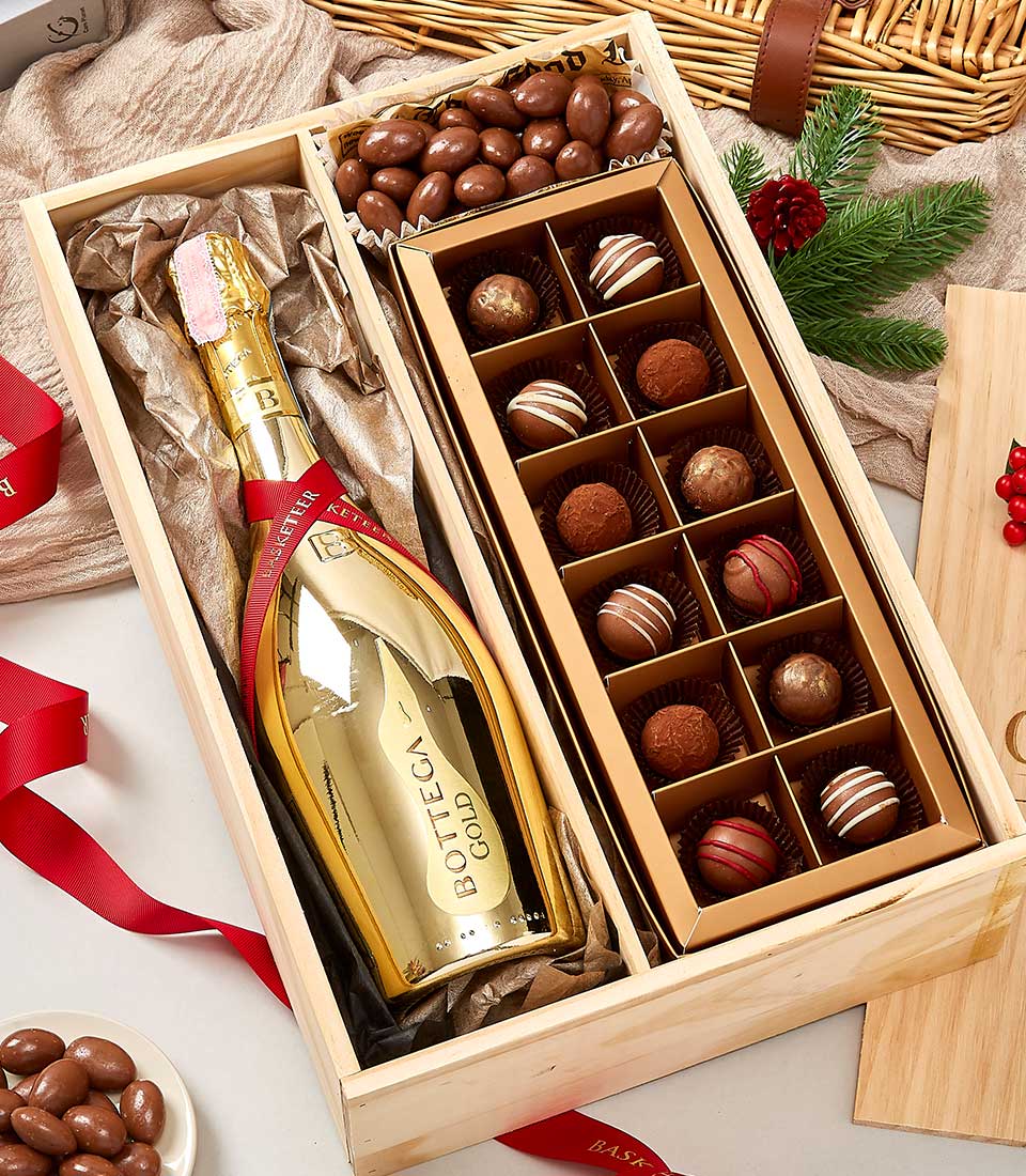 Luxury champagne and artisan chocolate gift box with sparkling wine, truffles, and chocolate-covered nuts in wooden