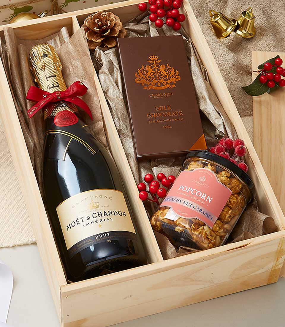 Champagne and gourmet chocolates gift box with caramel popcorn and festive berries