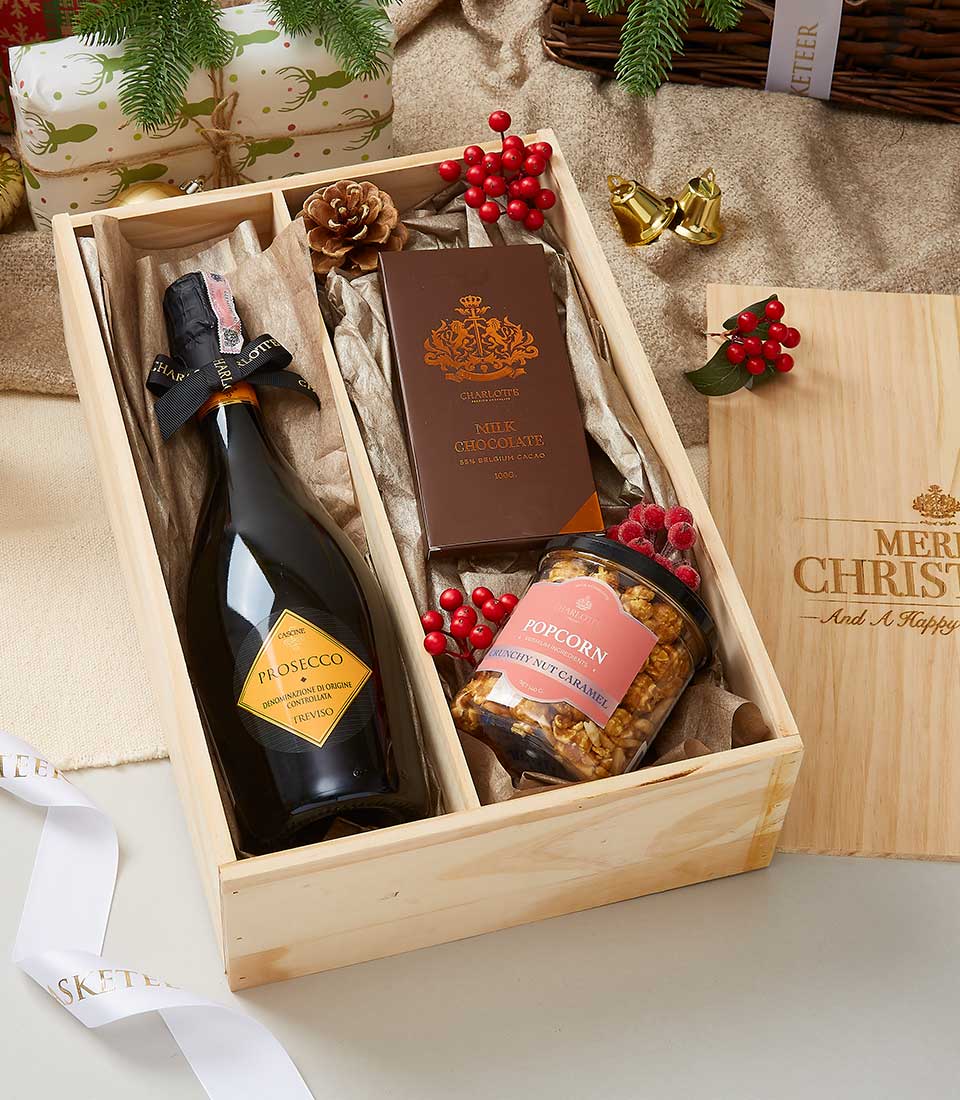 Prosecco, artisan chocolate, and gourmet popcorn gift box with holiday festive styling