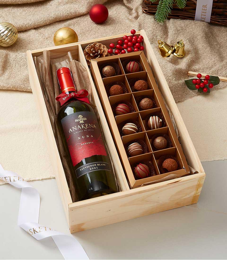 Sauvignon Blanc wine and luxury chocolates in light wooden gift box with festive red ribbon