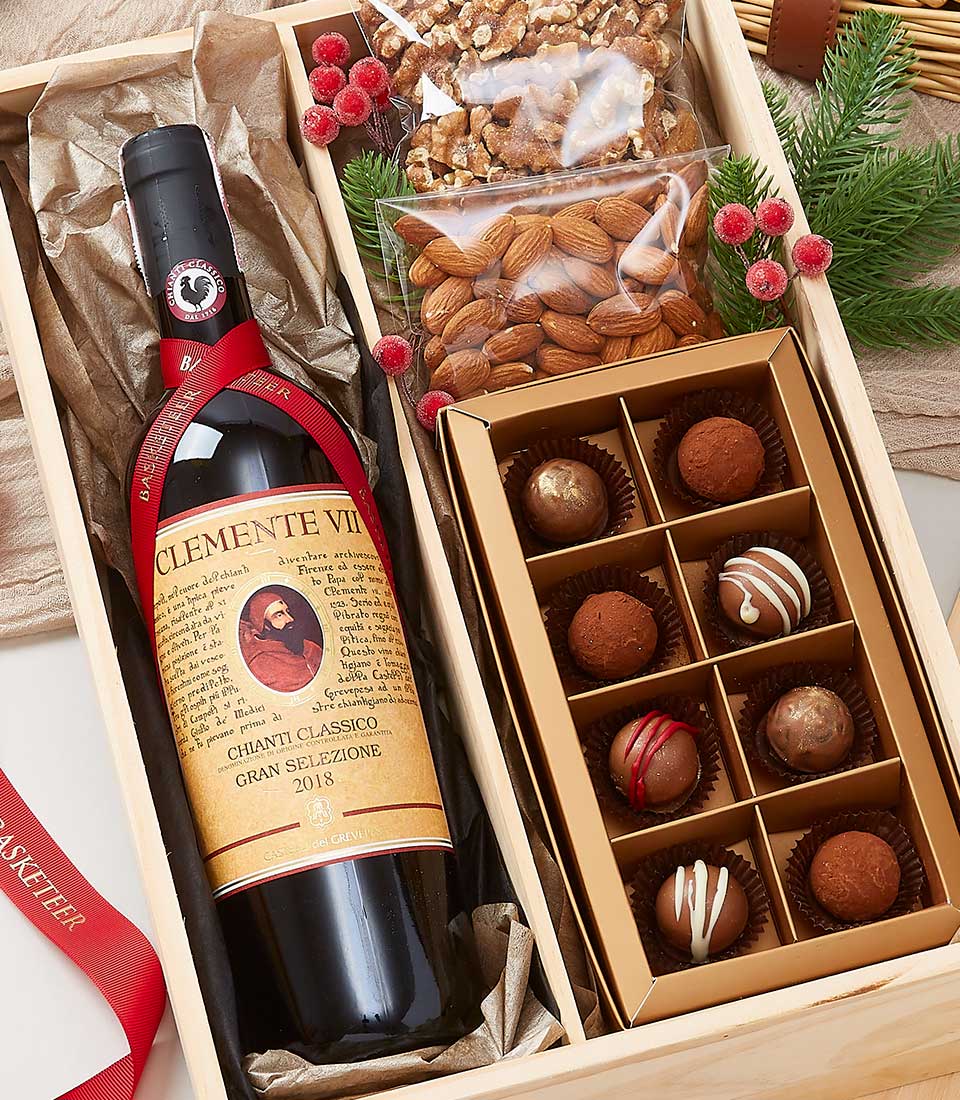 Chianti Classico red wine, roasted nuts, and assorted chocolate truffles in luxury wooden gift box with festive garnish