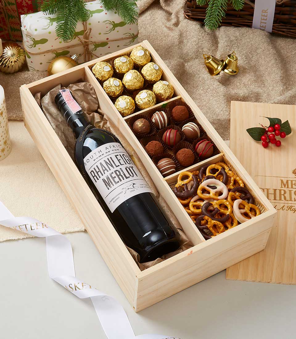 Premium wine and gourmet chocolate gift set in wooden crate with Merlot, gold-foiled chocolates, and artisan truffles