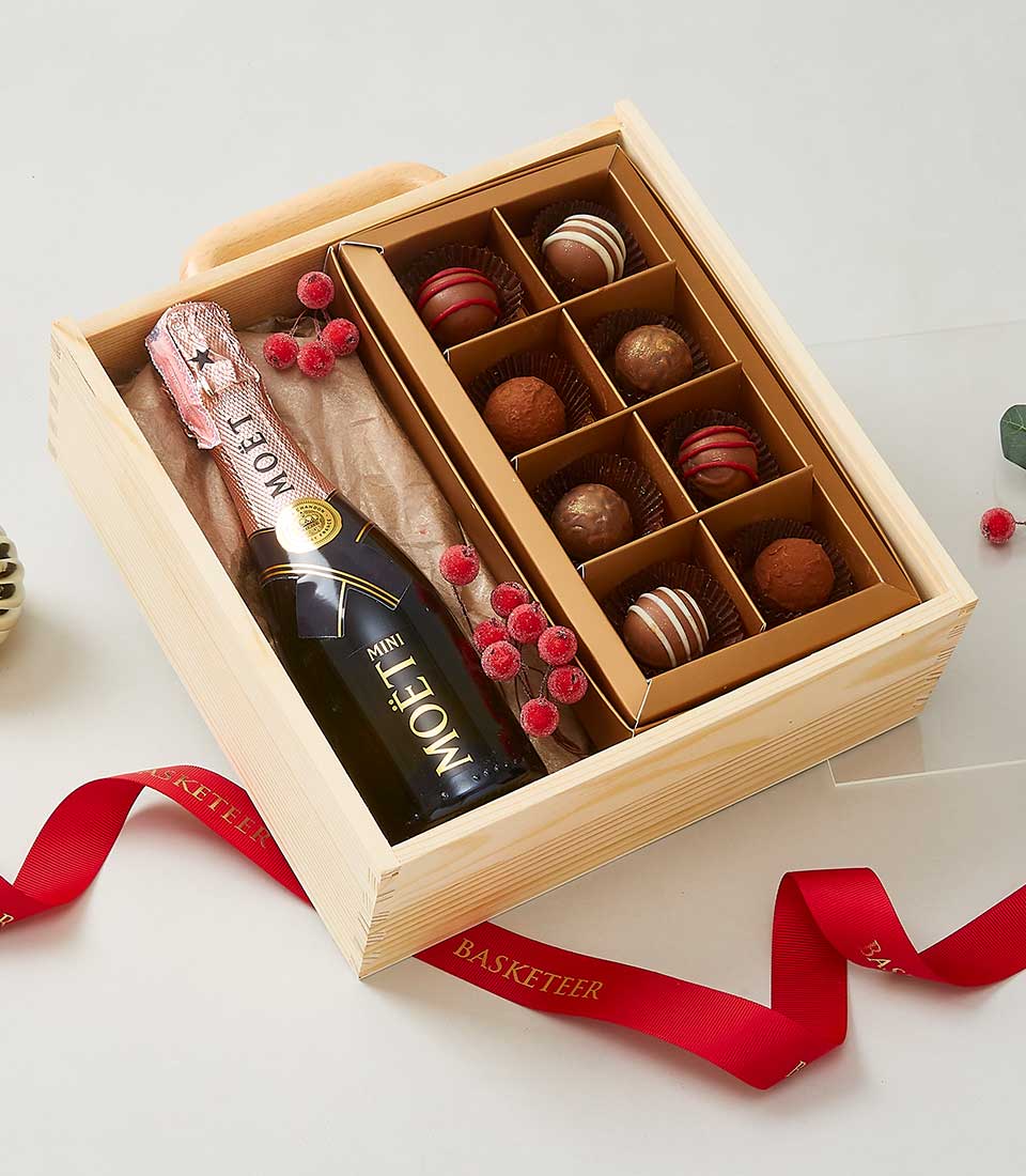 Champagne and assorted chocolates luxury gift box with frosted berries and red ribbon