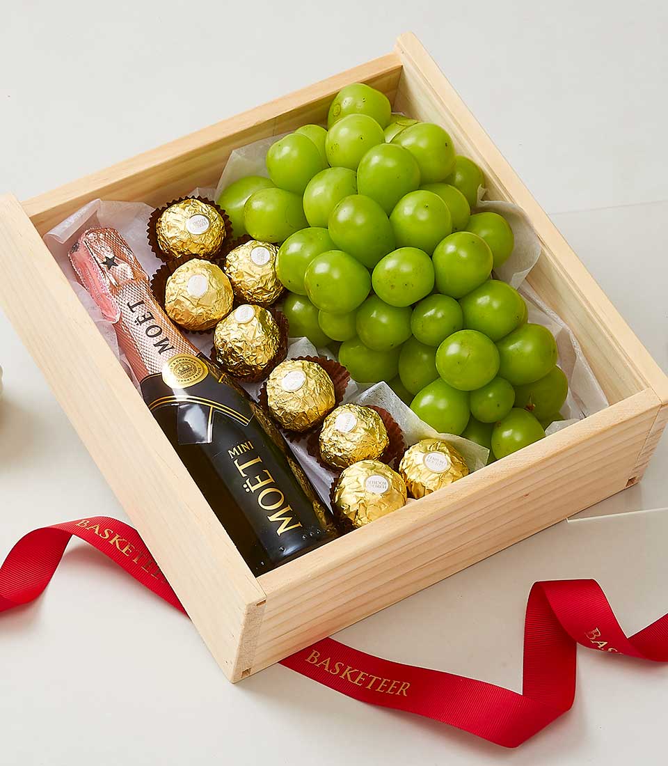 Deluxe wooden gift box with mini champagne, gold truffles, and fresh green grapes