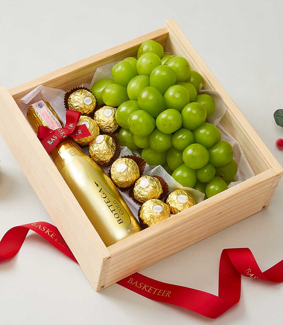 Luxe wine gift box with Bottega Gold champagne, fresh green grapes, and Ferrero Rocher chocolates in wooden presentation