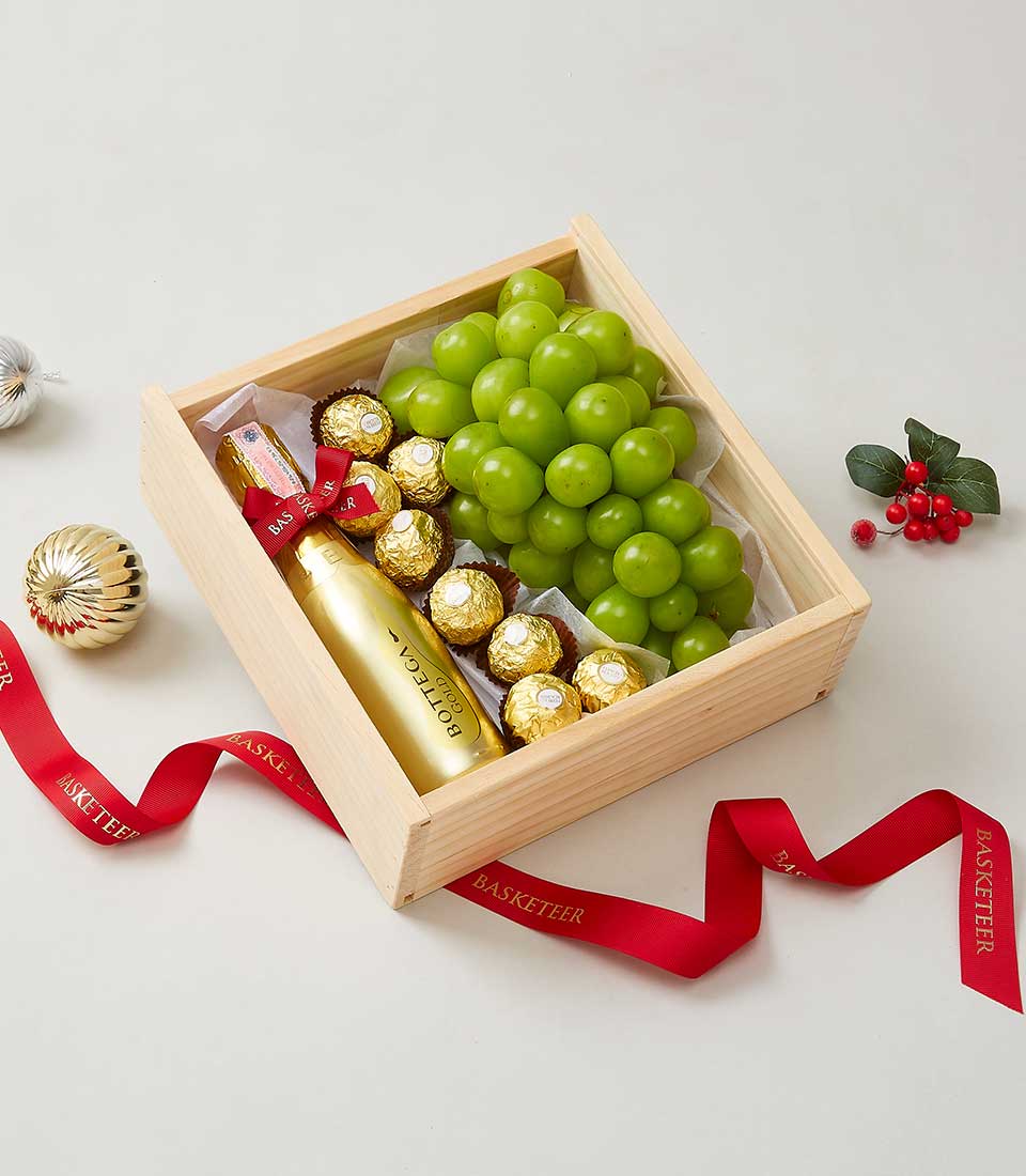 Premium wine gift box with Bottega Gold sparkling wine, green grapes, and gold-wrapped chocolates in wooden crate