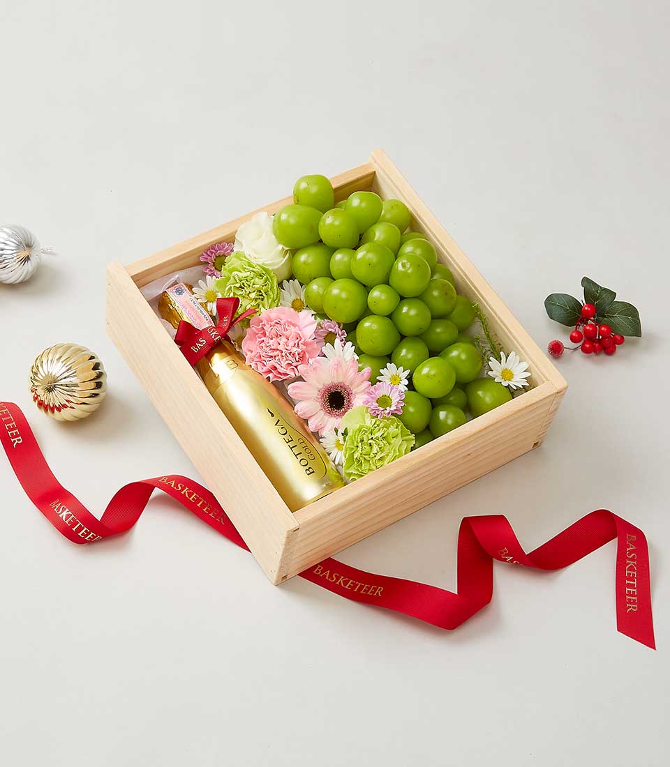 Premium gift box with Bottega Gold sparkling wine, fresh pink and white flowers, green grapes, and festive ribbons