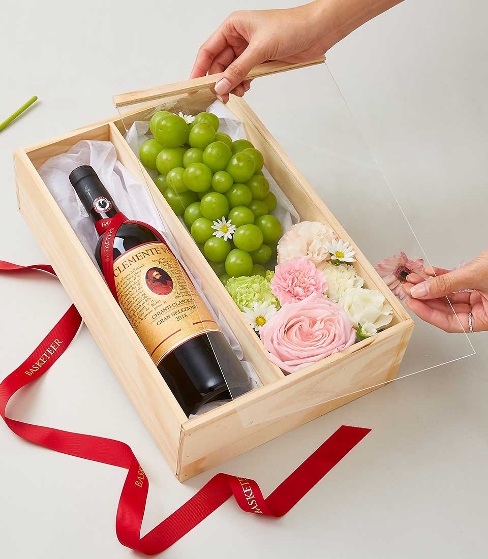 Deluxe wooden gift box with premium red wine, fresh roses and carnations, and green grapes