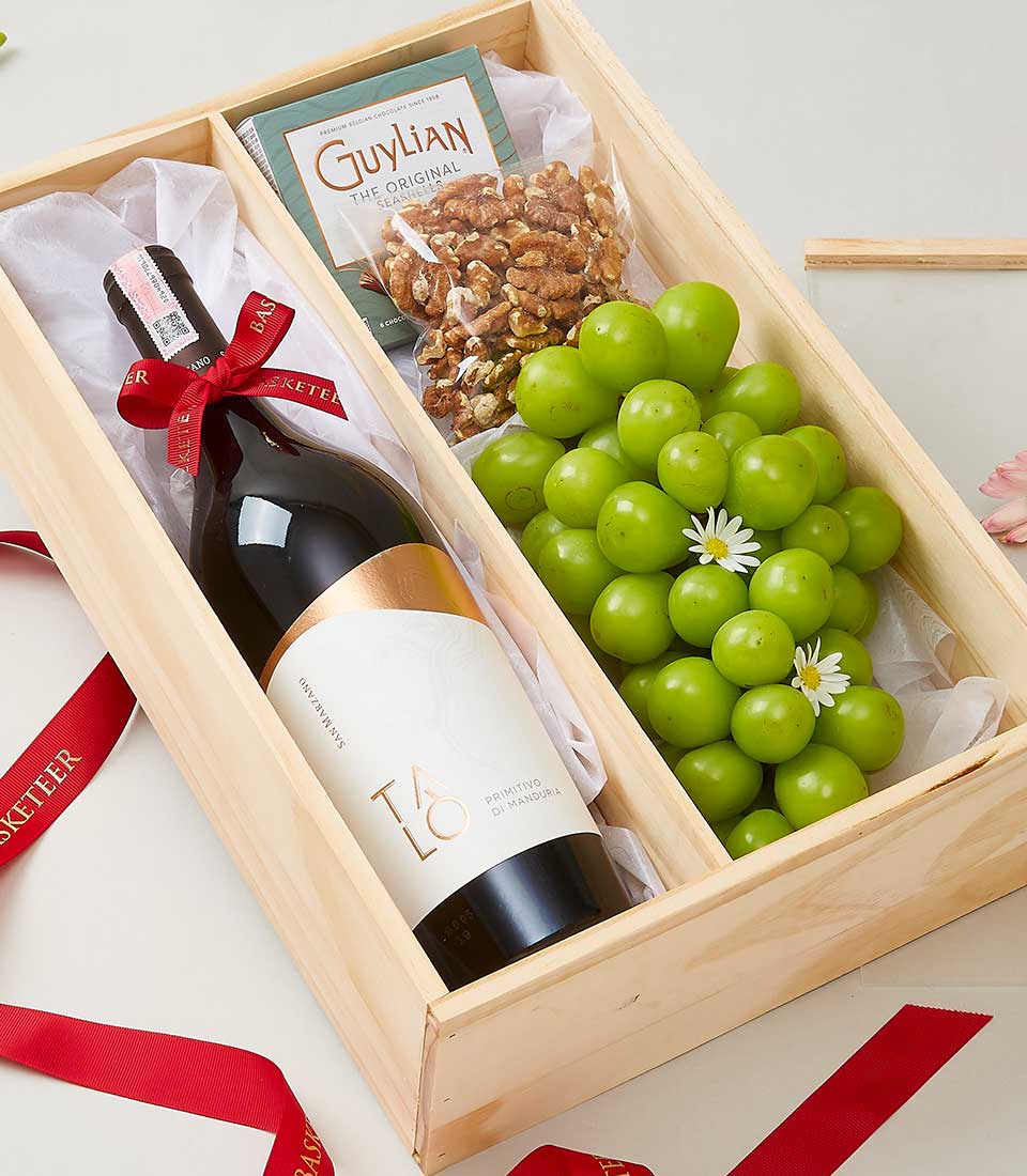 Premium wooden gift box with Talo Primitivo wine, walnuts, teal chocolates, and fresh green grapes with white flowers