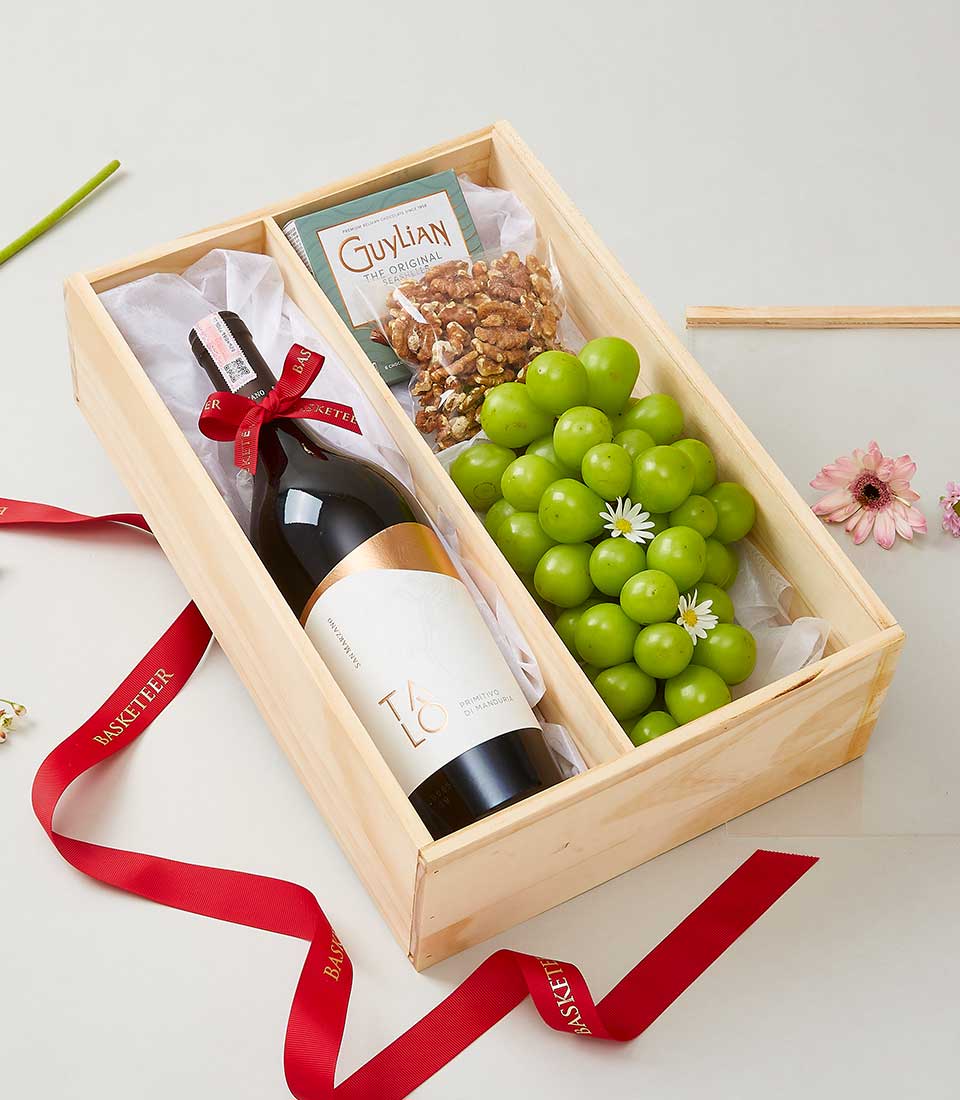 Talo Primitivo wine with gourmet chocolates, walnuts, and fresh green grapes in wooden gift box