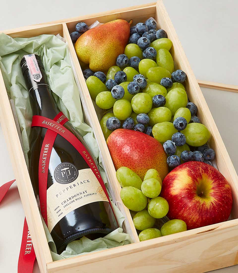 Premium wooden gift box with Chardonnay wine, red ribbon, and fresh fruit assortment including grapes, pears, blueberries,