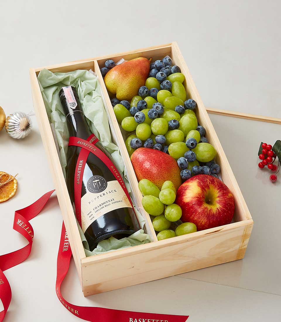 Premium wine and fresh fruit gift box with white wine, grapes, berries, and pear in natural wood case