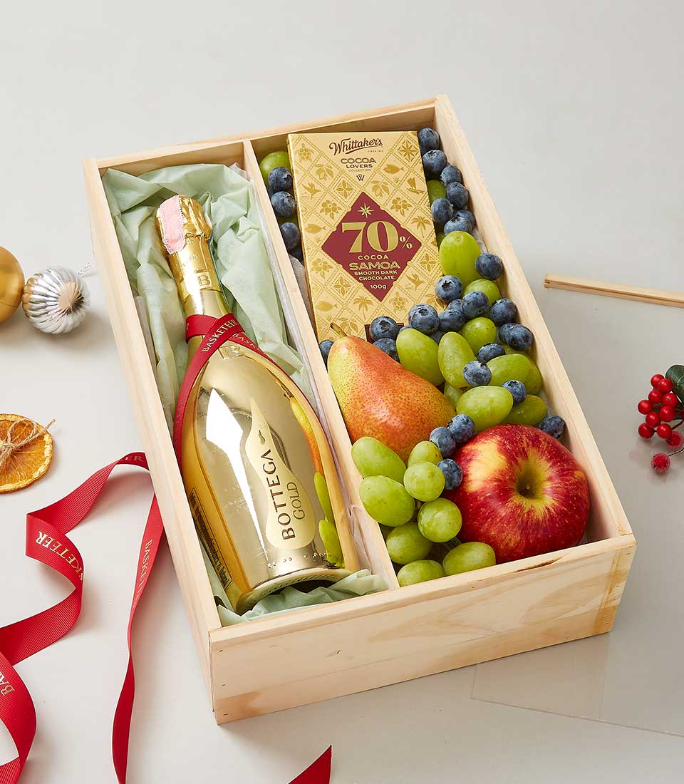 Bottega Prosecco Gold Brut with fresh fruit, dark chocolate, and festive berries in wooden gift box