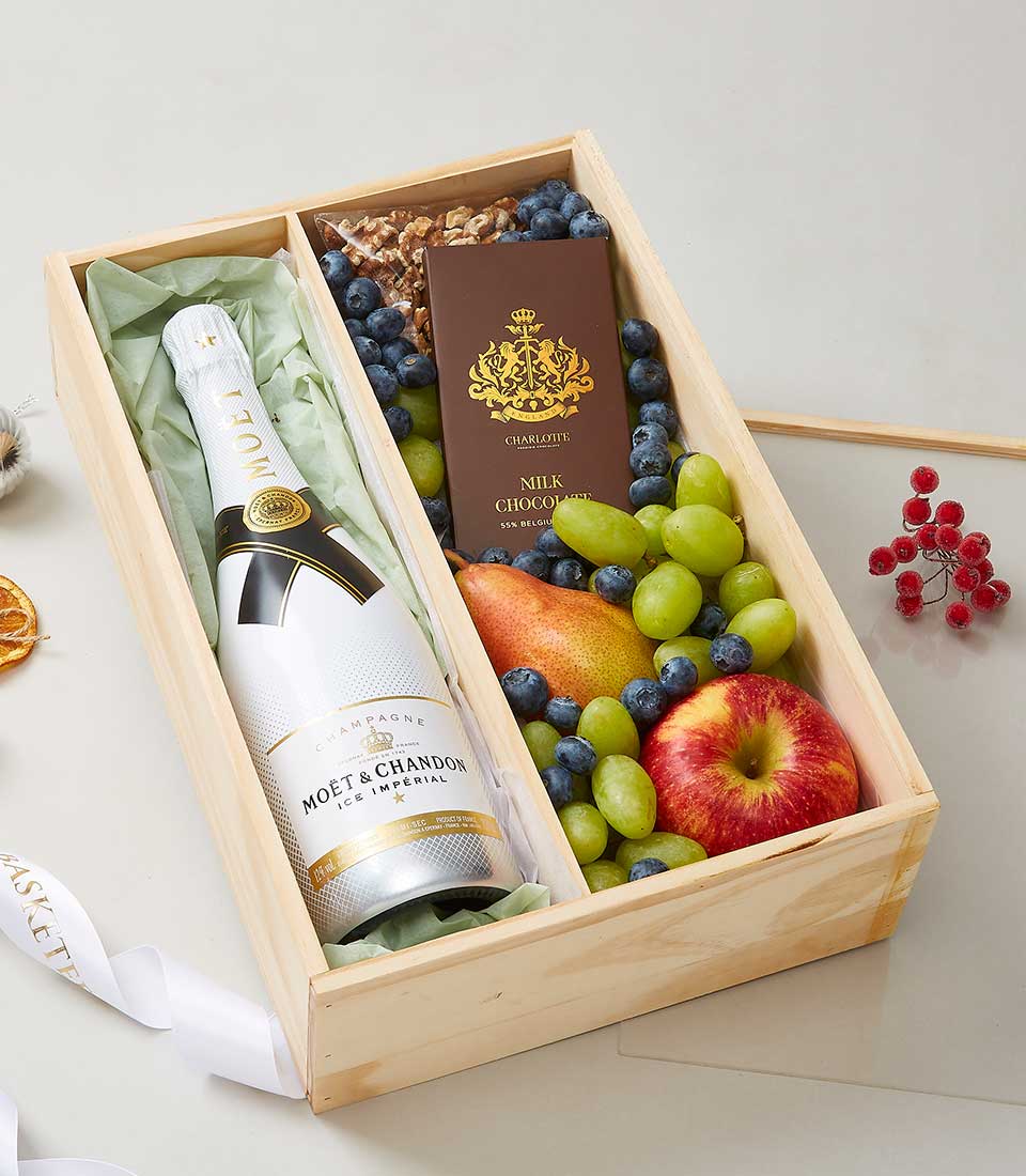 Moët & Chandon champagne gift box with fresh fruit, chocolate, and walnuts in wooden compartments