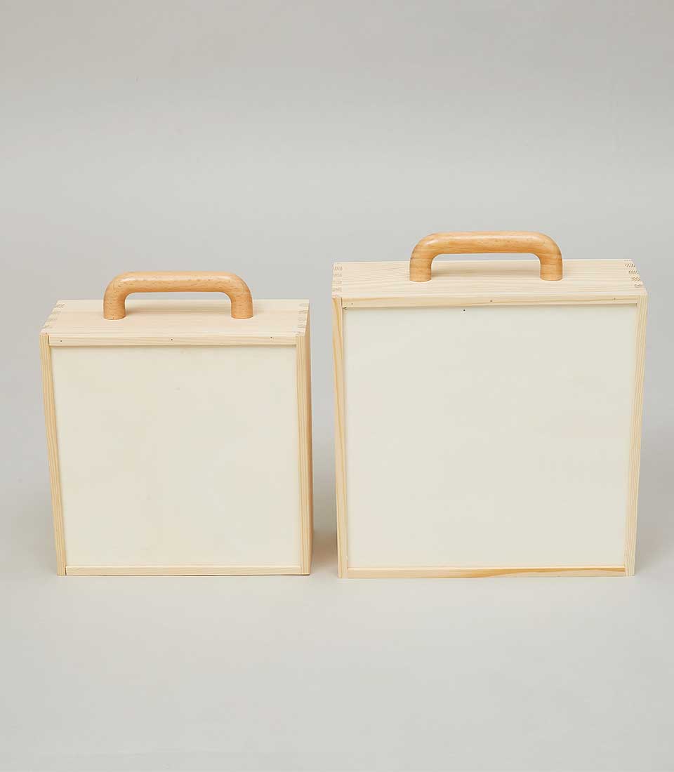 Nested wooden storage boxes with curved handles and light pine construction, ideal for luxury gift hampers and artisan