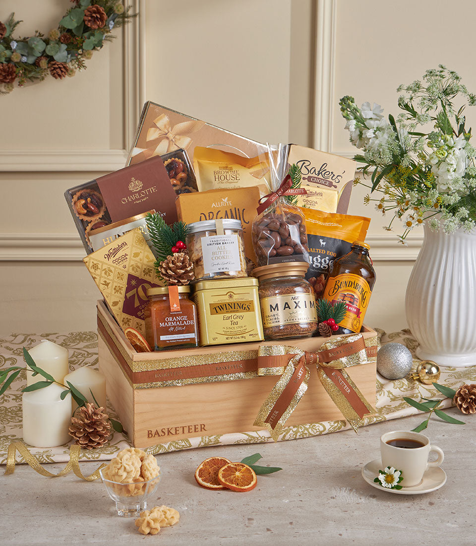 Wooden gourmet hamper with marmalade, coffee, tea, and chocolates tied with gold ribbon for New Year gifting