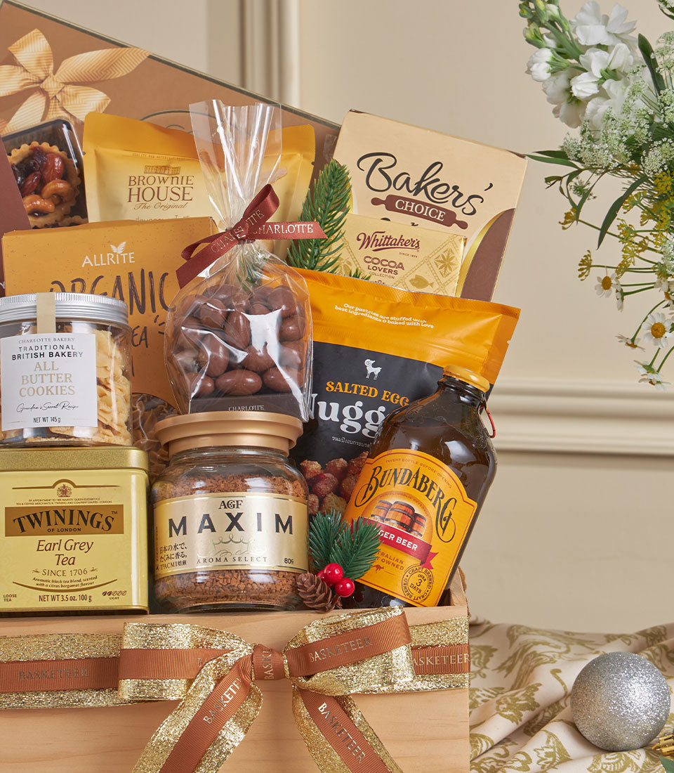Basketeer premium hamper filled with gourmet treats: cookies, chocolates, coffee, and Bundaberg ginger beer. Wooden crate tied with a gold ribbon. Perfect corporate gift Bangkok.