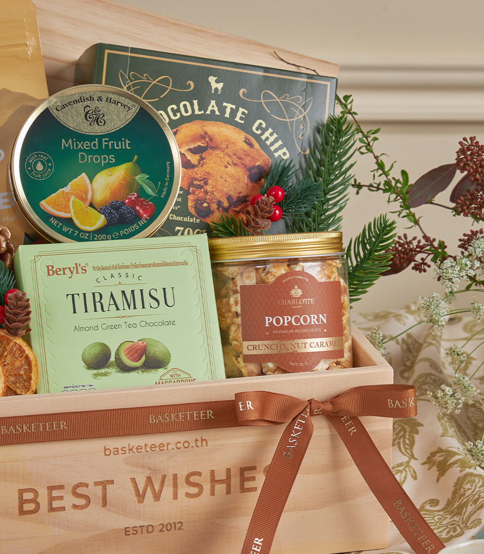 Warm wooden gift basket with gourmet treats, green tea chocolate, and caramel popcorn tied with brown ribbon for New Year