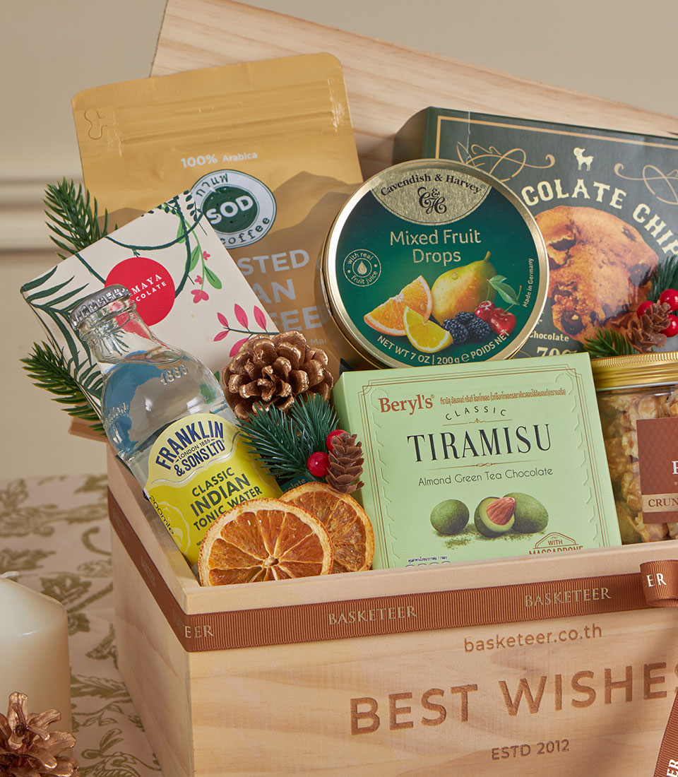 Warm wooden gift basket with gourmet coffee, tea chocolate, and festive pine and citrus accents for New Year