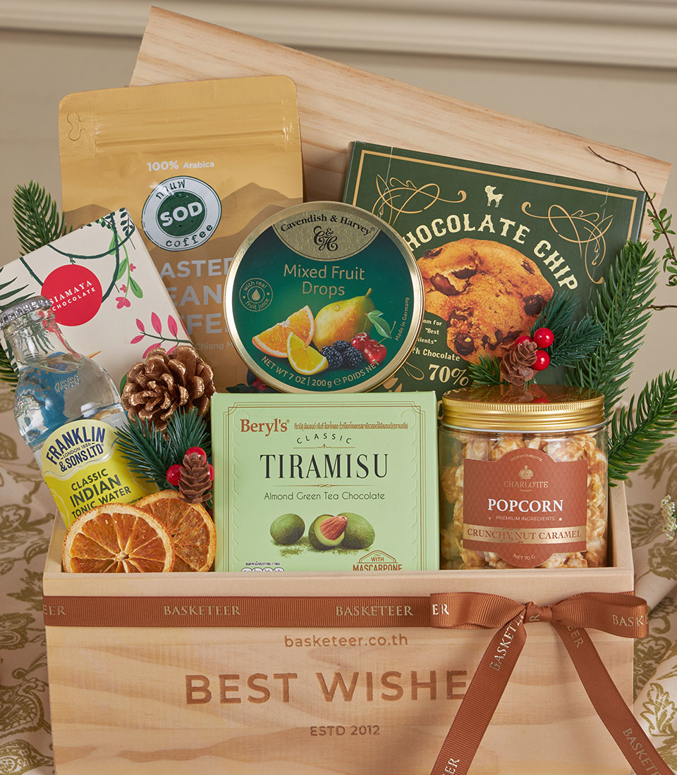 Wooden gift crate with gourmet treats, coffee, chocolate, and festive greenery for New Year gifting
