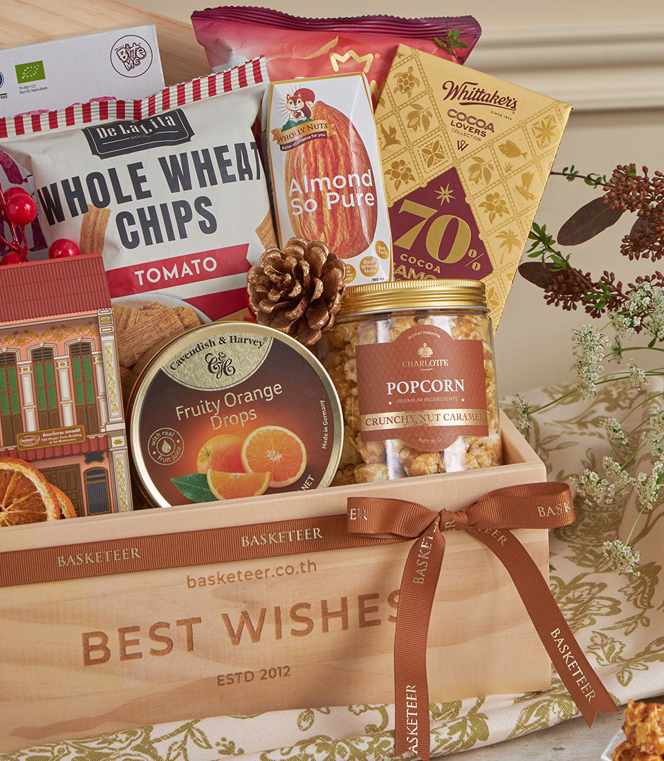 Wooden gift box filled with gourmet snacks, dark chocolate, and nuts for New Year gifting
