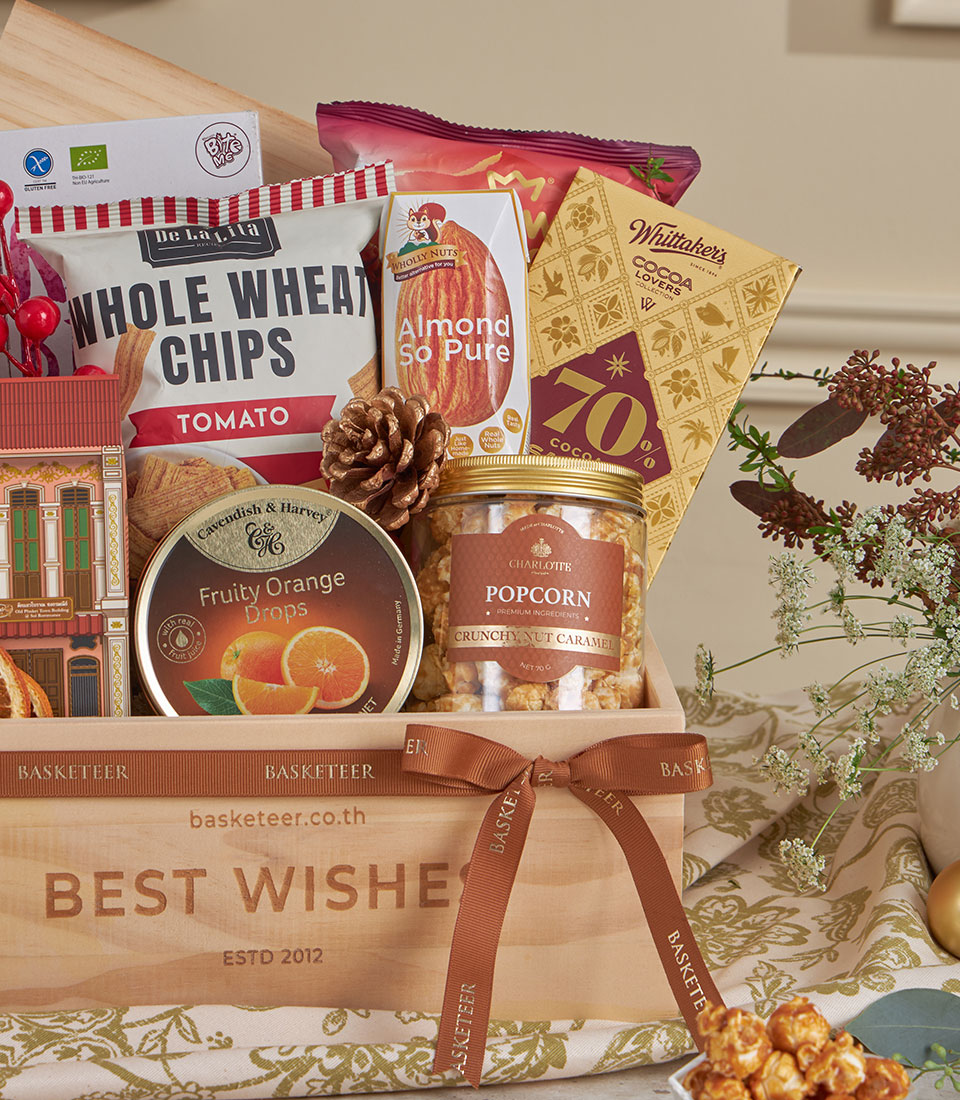 Wooden gift box with gourmet snacks, almonds, caramel popcorn, and chocolate for New Year gifting