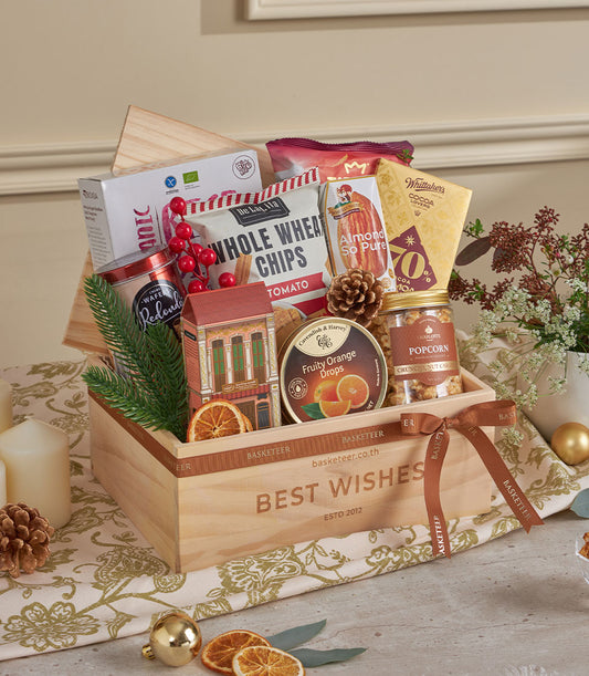 Wooden gift box filled with gourmet snacks, almonds, caramel popcorn, and chocolate for New Year gifting