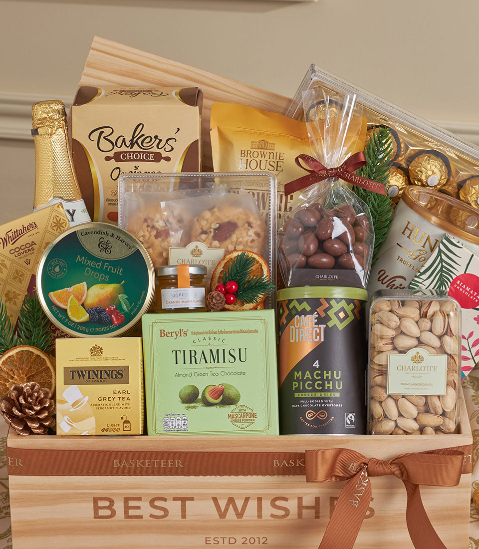 Golden luxury gourmet gift basket with champagne, chocolates, tea, coffee, and festive trimmings for New Year celebrations