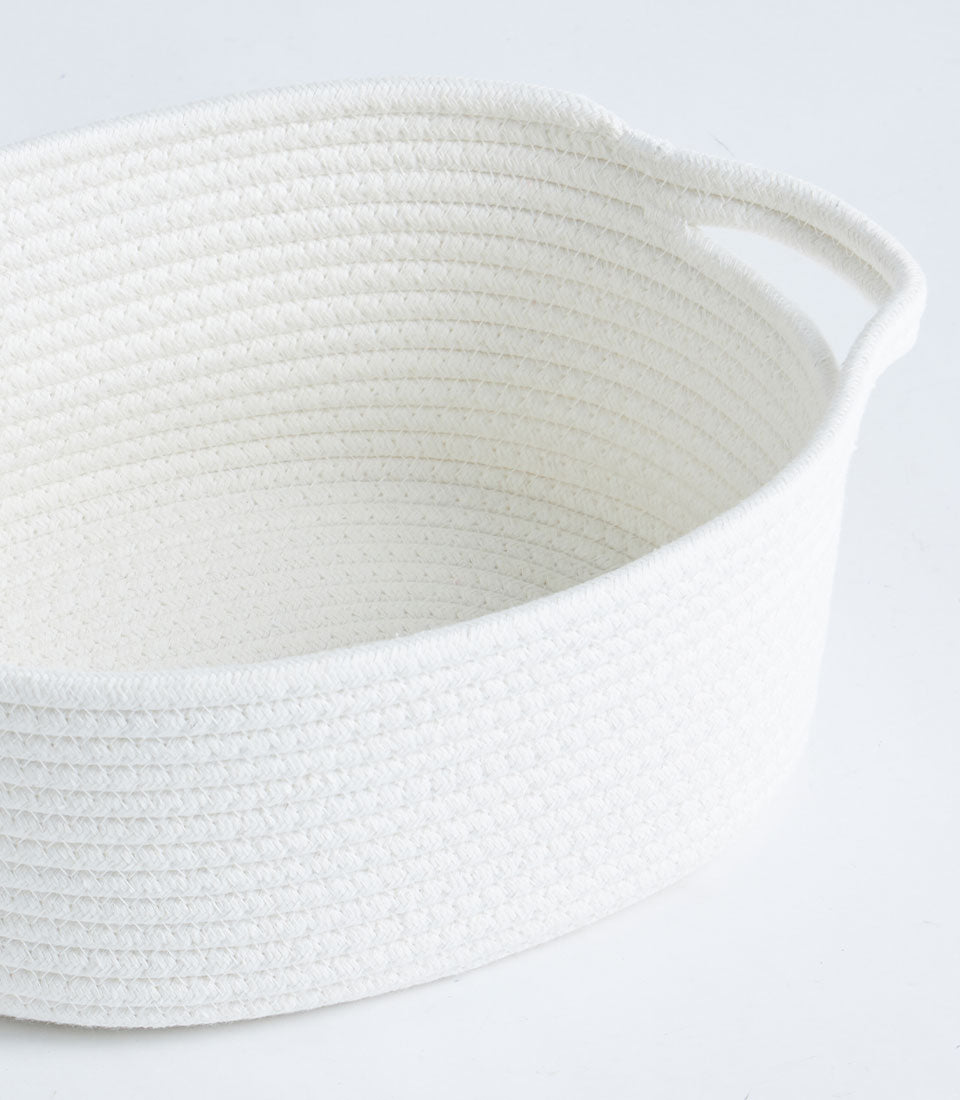 White cotton rope storage basket with dual handles and coiled texture