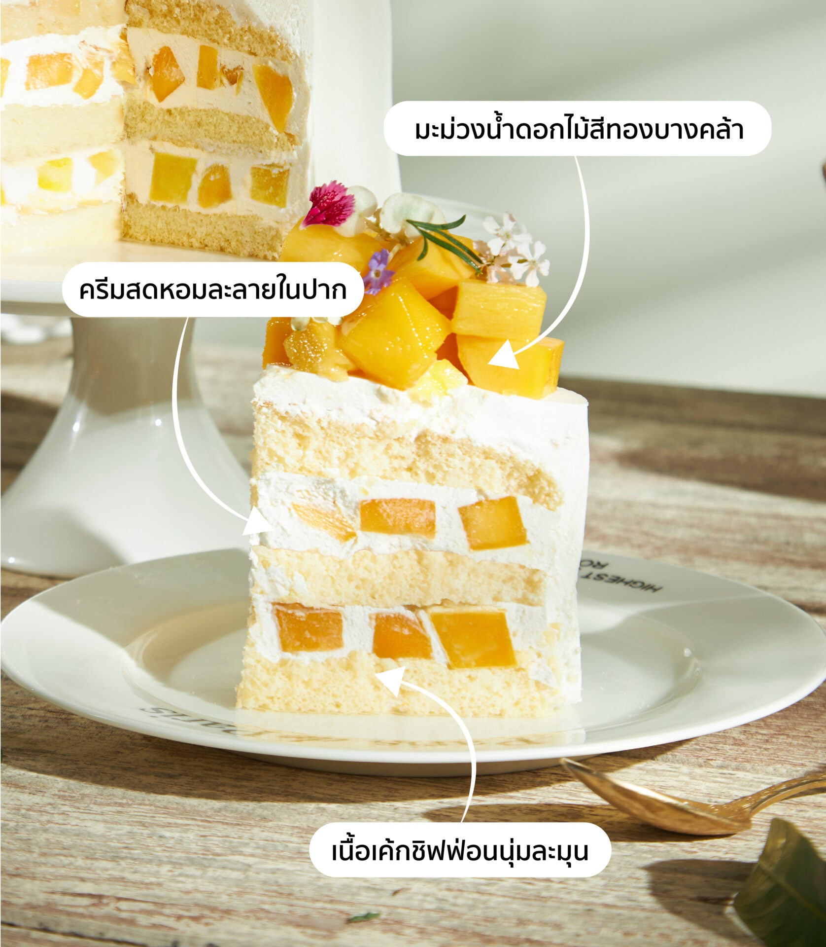 Mango chiffon cake slice with fresh cream, diced mango, and edible flowers on ceramic plate